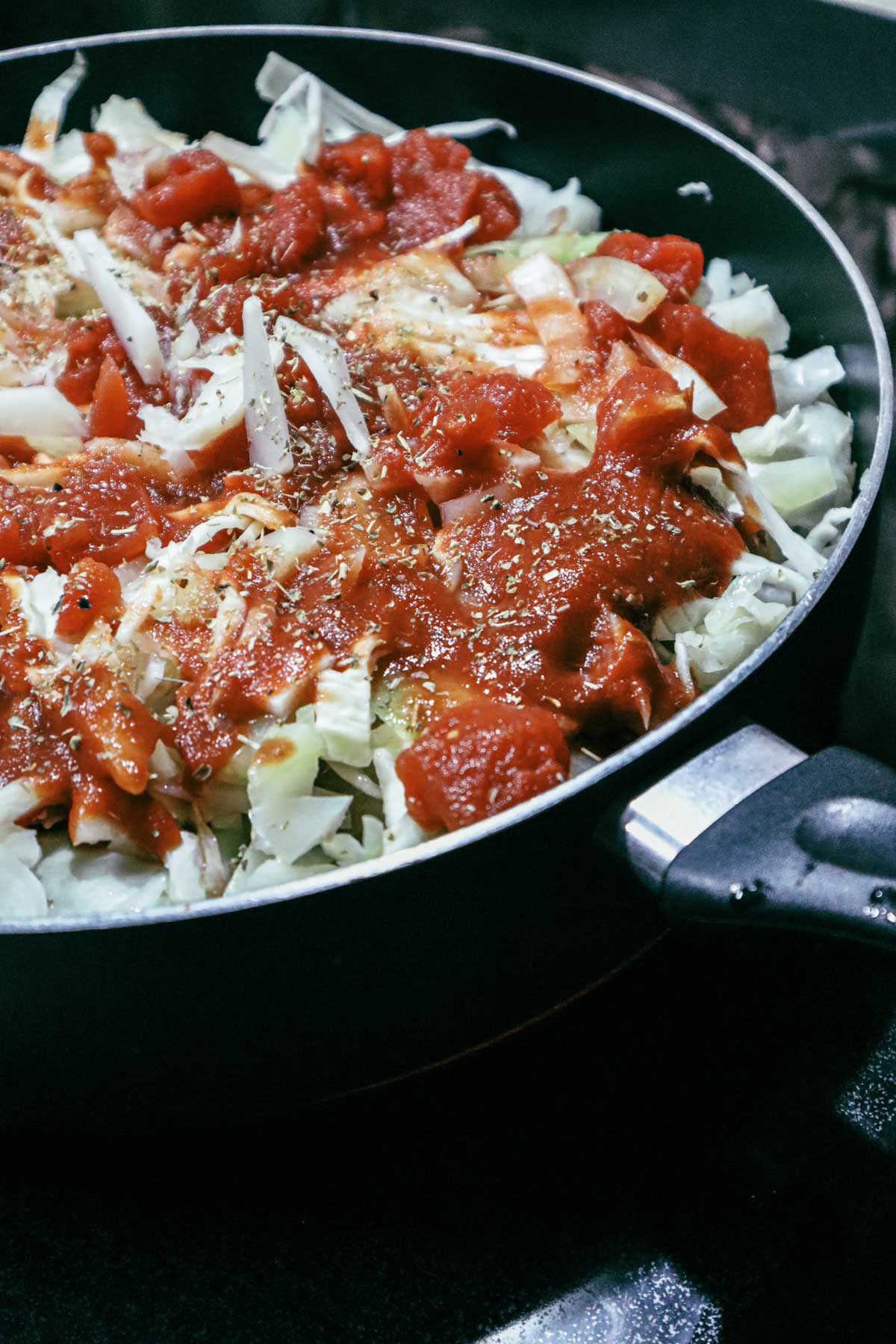 Rolls in a large pan, covered of tomato sauce and shredded cabbage. Ready to cook.