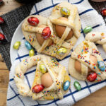 Sicilian Easter cookies close up photo on a kitchen towel decorated with the chocolate filled eggs.