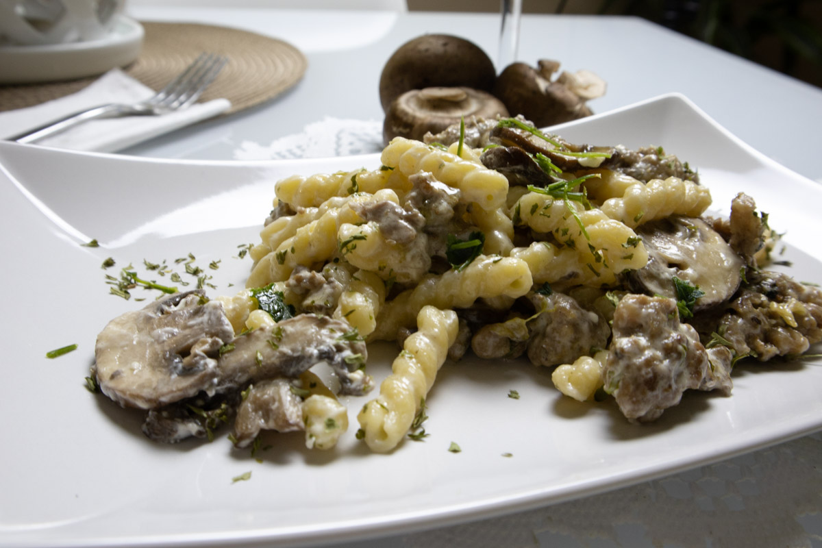 Creamy Italian Sausage Pasta with Mushrooms Creamy Italian sausage pasta with mushrooms and Parmesan served on a white plate.