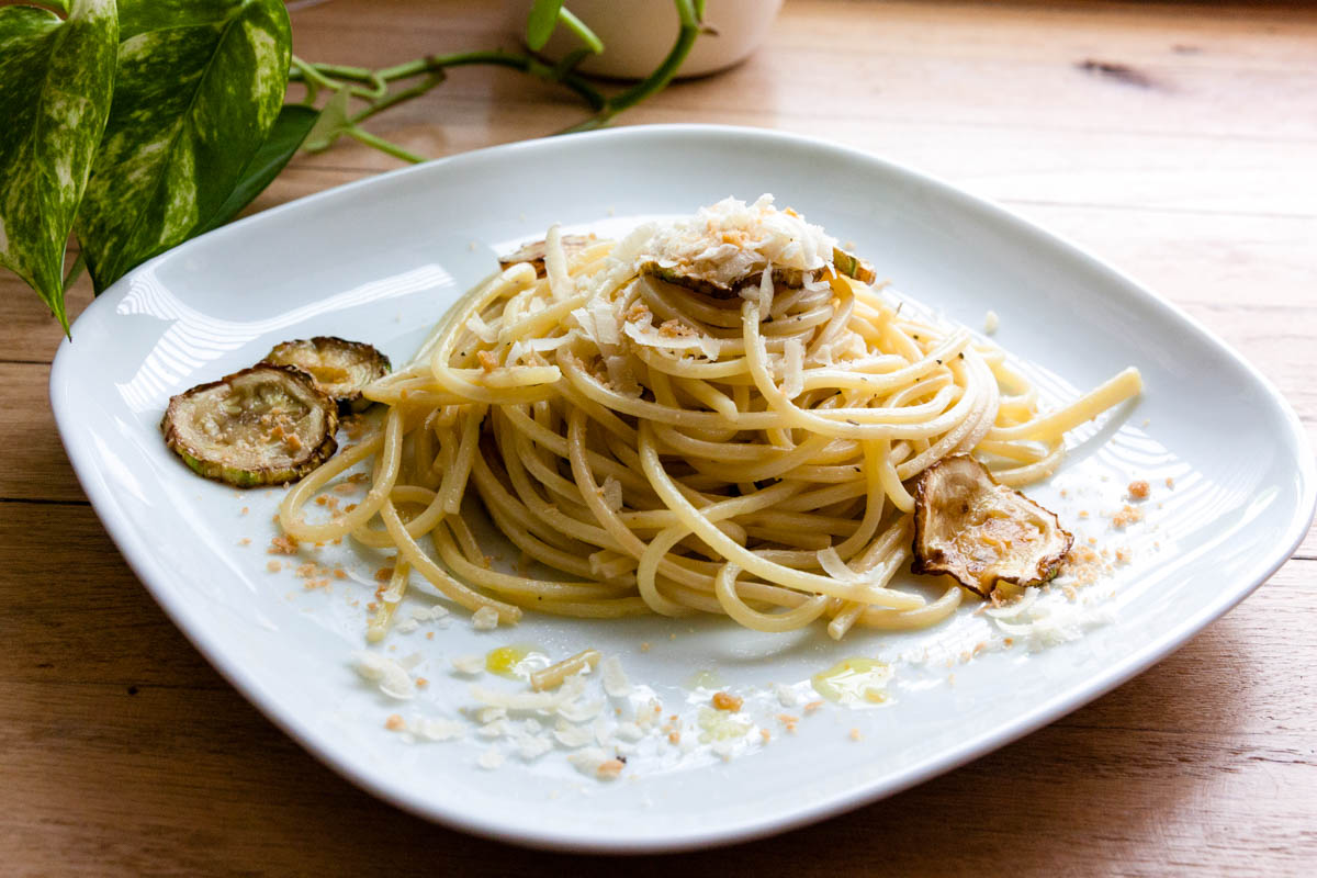 Closeup of pasta with fried zucchini and grated ricotta salata.